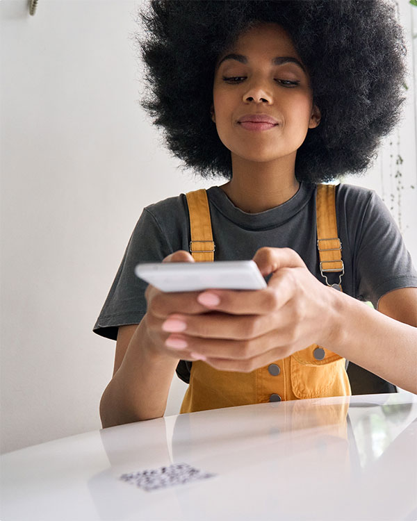 Blog featured image:Contactless Integrated Payments QR Code Solutions. image of a woman making a payment on her device